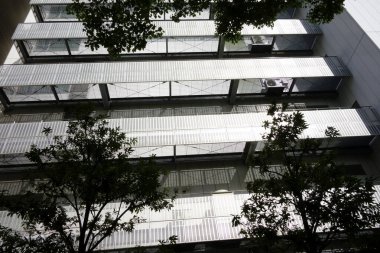 Şehirde modern bir bina, parlak ama göz kamaştırıcı gümüş bir balkon.