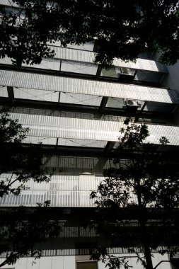 Şehirde modern bir bina, parlak ama göz kamaştırıcı gümüş bir balkon.