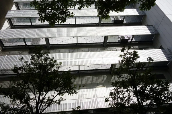 Şehirde modern bir bina, parlak ama göz kamaştırıcı gümüş bir balkon.