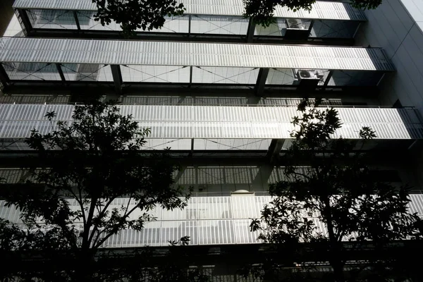 Şehirde modern bir bina, parlak ama göz kamaştırıcı gümüş bir balkon.