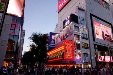 Shinjuku, Tokyo, Japonya - 3 Ağustos 2023: Dünyaca ünlü Shinjuku Doğu Çıkışı, Kabukicho, neon aydınlatmaları ve Tokyo 'nun hareketli eğlence bölgesinde yürüyen insanlar.