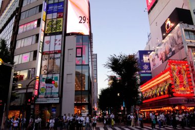 Shinjuku, Tokyo, Japonya - 3 Ağustos 2023: Dünyaca ünlü Shinjuku Doğu Çıkışı, Kabukicho, neon aydınlatmaları ve Tokyo 'nun hareketli eğlence bölgesinde yürüyen insanlar.