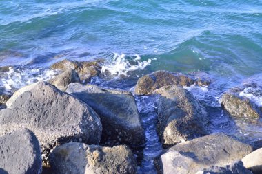 Sahilde kayalıklara vuran denizin göz kamaştırıcı sıçraması.
