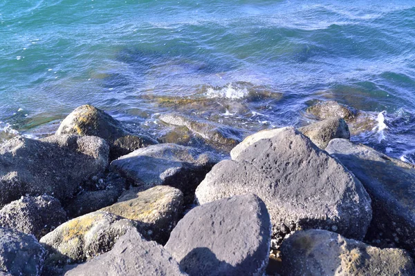 Sahilde kayalıklara vuran denizin göz kamaştırıcı sıçraması.
