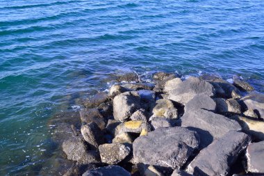 Sahilde kayalıklara vuran denizin göz kamaştırıcı sıçraması.