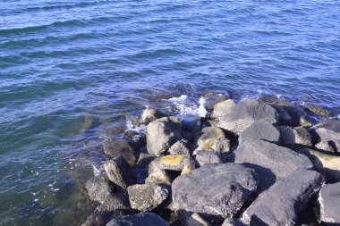 Sahilde kayalıklara vuran denizin göz kamaştırıcı sıçraması.