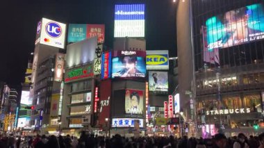 Tokyo, Japonya, Shibuya İstasyonu Scramble Geçidi, kalabalık ve gürültülü gece görüşü