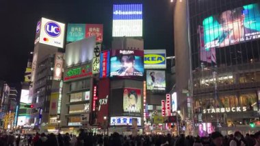 Tokyo, Japonya, Shibuya İstasyonu Scramble Geçidi, kalabalık ve gürültülü gece görüşü