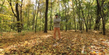 man in autumn forest with golden balloons
