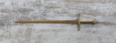 Beyaz ahşap arka planda altın kılıçlı kılıç