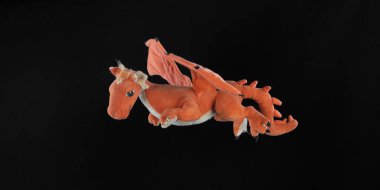 orange dragon toy isolated on black background