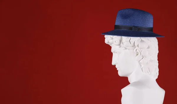 hat on white plaster head sculpture