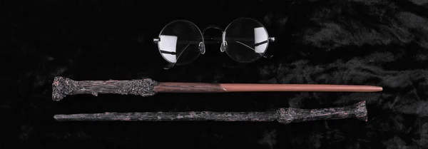 magic wand and glasses on a black background