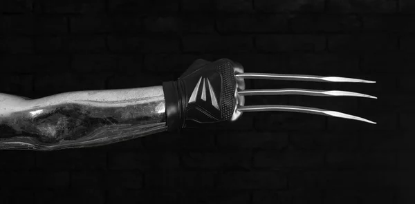 黒の背景に刃の爪の武器で手 — ストック写真