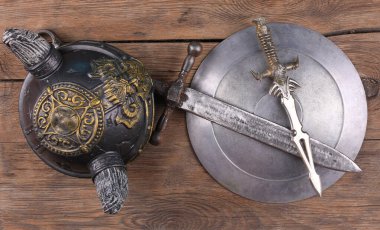 Şövalye zırhı, kılıç ve kalkan ahşap arka planda