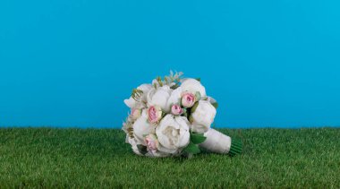 Çimlerin üzerinde bir buket beyaz gül.