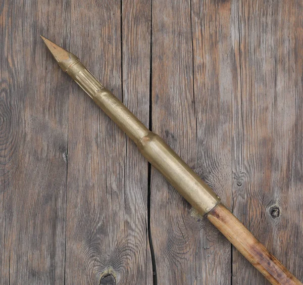 木製の背景に黄金の槍の武器 — ストック写真