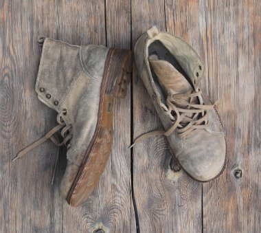 Ahşap arka planda eski deri dağ çizmeleri
