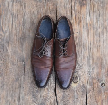 Eski kahverengi deri klasik erkek ayakkabıları ahşap zeminde