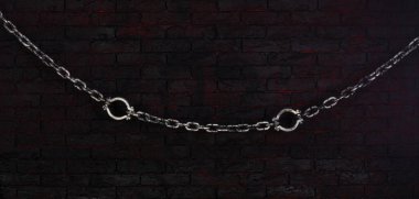 prison chains on a black brick wall clipart