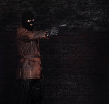 Siyah arka planda silahlı, maskeli bir haydut.