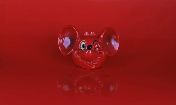 red toy mouse head on red background