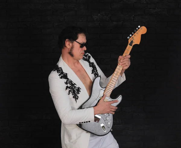 stock image portrait of a male rock guitarist on a black background