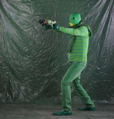 Uzay silahına sahip yeşil uzaylı