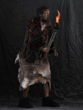 Elinde meşale olan bir mağara adamı portresi.