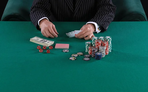 hands of a poker player on a green card table