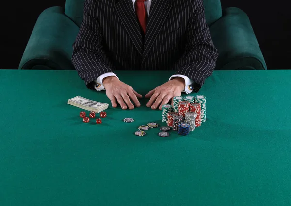 hands of a poker player on a green card table