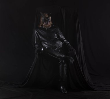 Siyah arka planda canavar maskeli bir adamın portresi.