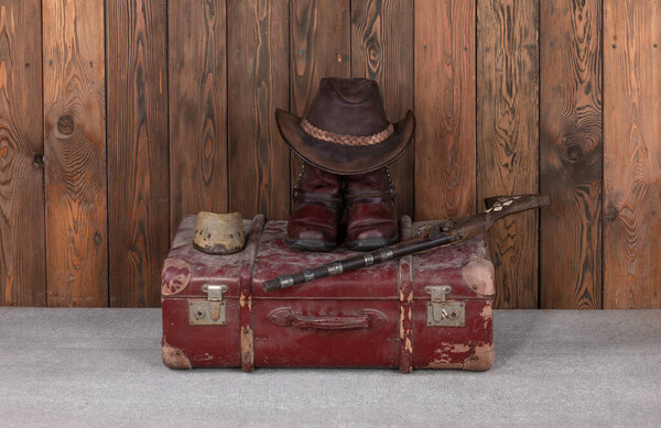 ковбойская шляпа, сапоги и пистолет на деревянном полу
