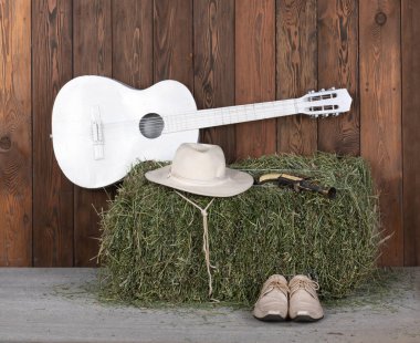 Gitar, kovboy çizmesi ve tahta zeminde silah.