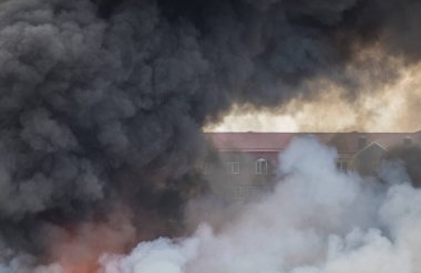 Yanan binalar ve bir depo, şehirde duman ve yangın
