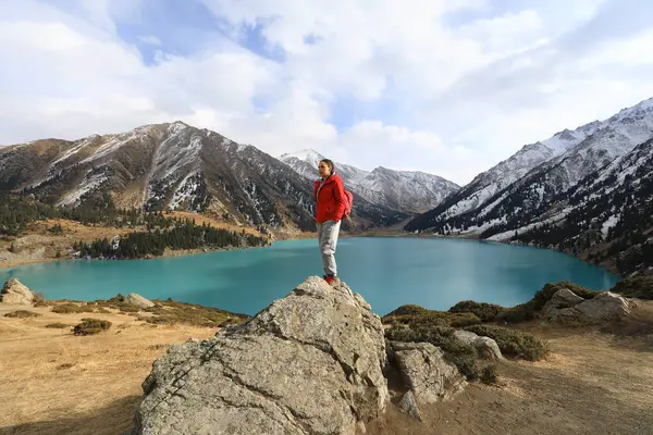 woman stands on a mountain, a mountain lake, glaciers.Big Almaty Lake, Kazakhstan, Almaty