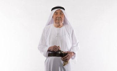 Beyaz elbiseli yaşlı bir Arap 'ın beyaz arka plandaki stüdyo portresi.