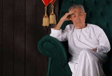 Beyaz elbiseli, dindar, yaşlı bir adamın portresi.