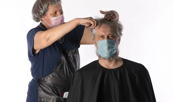 portrait of a hairdresser in a medical mask on a white background