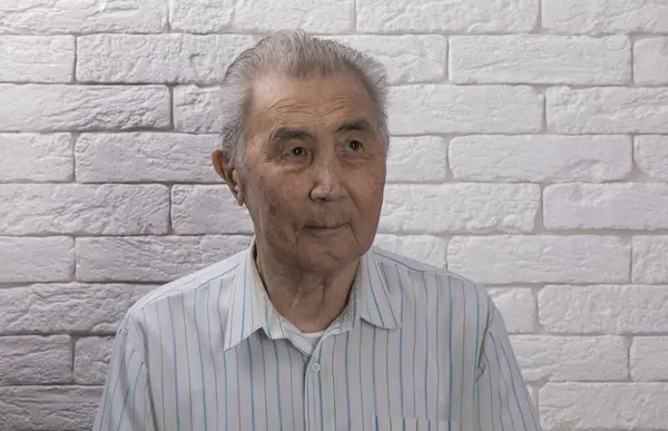 close-up portrait of an old asian man on white studio background