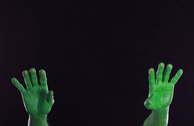 Siyah arkaplanda yeşil boyalı eller