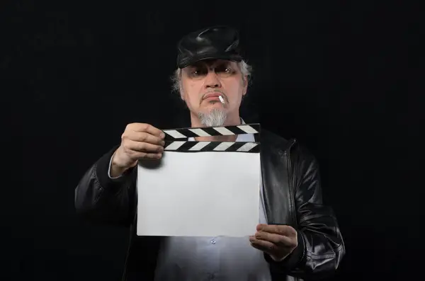 male film director with movie clapper on black background