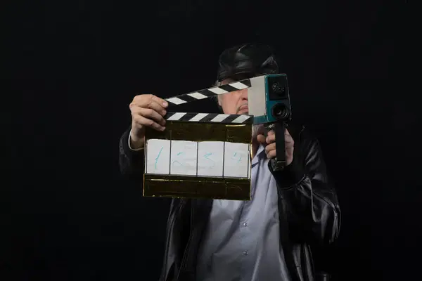 male film director with movie clapper on black background