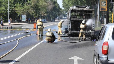 Kazakistan, Almaty, 4 Haziran 2020: yolda yanan otobüs ve itfaiyeciler