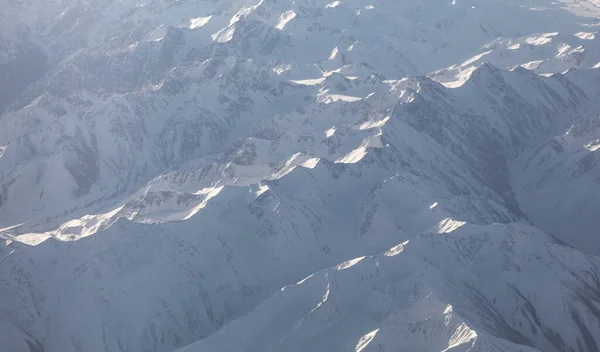 view of the snowy mountain landscape from an airplane