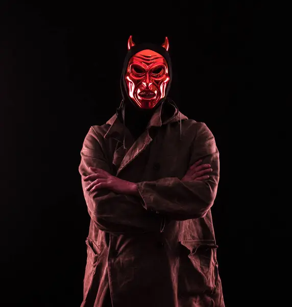 portrait of a man in a devil mask on a black background