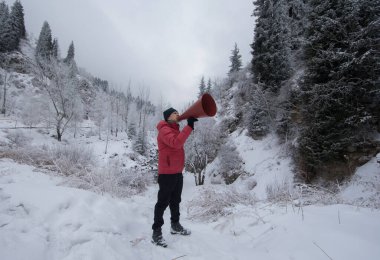 Kışın dağlarda hoparlörlü bir adam