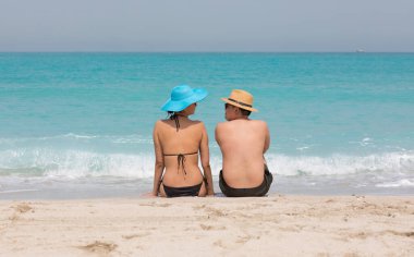 Erkek ve kız sahilde yüzüyorlar.