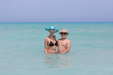 Erkek ve kız sahilde yüzüyorlar.