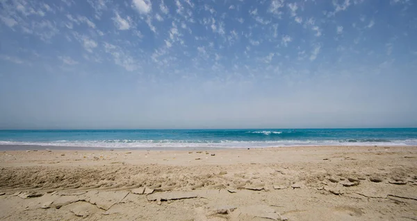 panoramic photo of beach sand, blue sea and blue sky